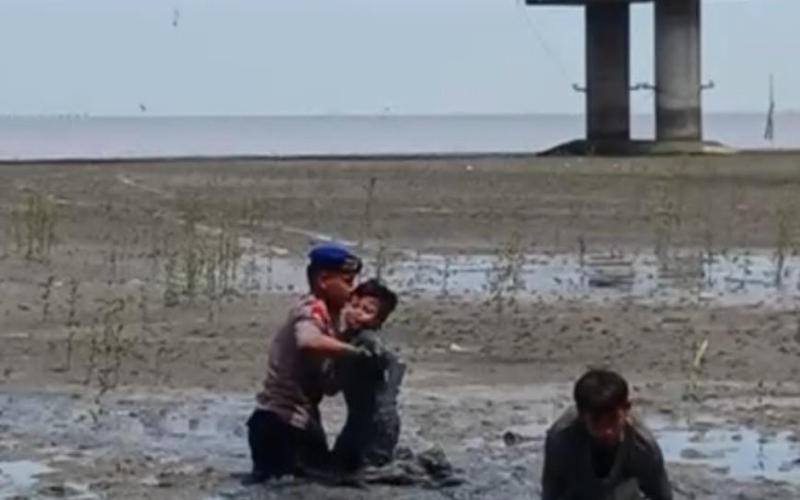 Ketika Lumpur Kenjeran Menyedot Dua Wisatawan Anak Penyelamatan dua anak terjebak lumpur oleh personel Dit Polairud Polda Jawa Timur di wisata Kenjeran (Foto: Dit Polairud Polda Jawa Timur)