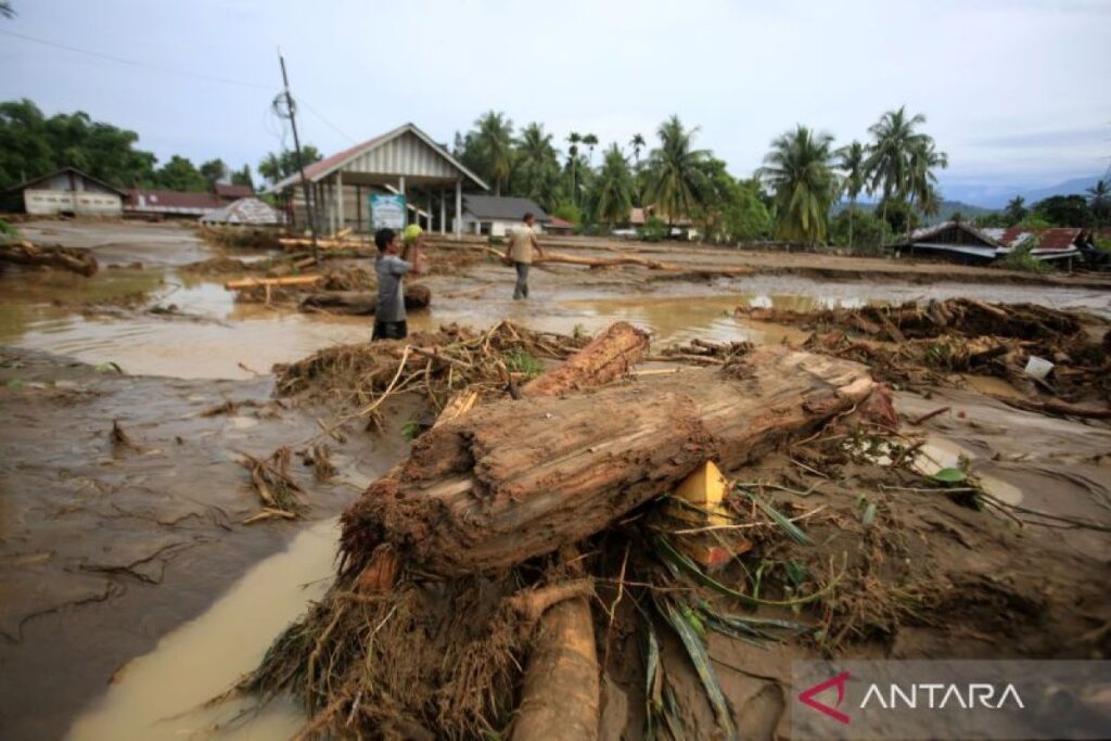 Perusak Lingkungan Harus Ditindak Jika Tak Ingin Terjadi Malapetaka Nasional Warga menyaksikan sejumlah rumah rusak tertimbun lumpur dan sampah kayu setelah diterjang banjir bandang di Kabupaten Pidie, Aceh, Kamis (27/11/2025). (Foto: Antara/Ampelsa)